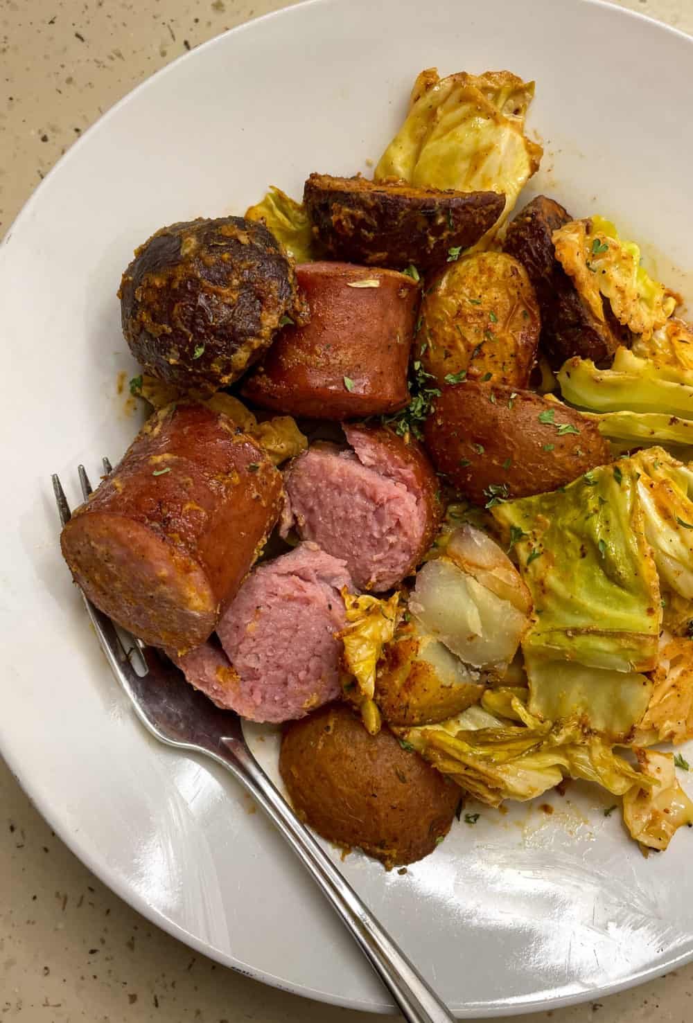 A bowl of kielbasa, cabbage and potatoes tossed together with a simple mustard vinaigrette